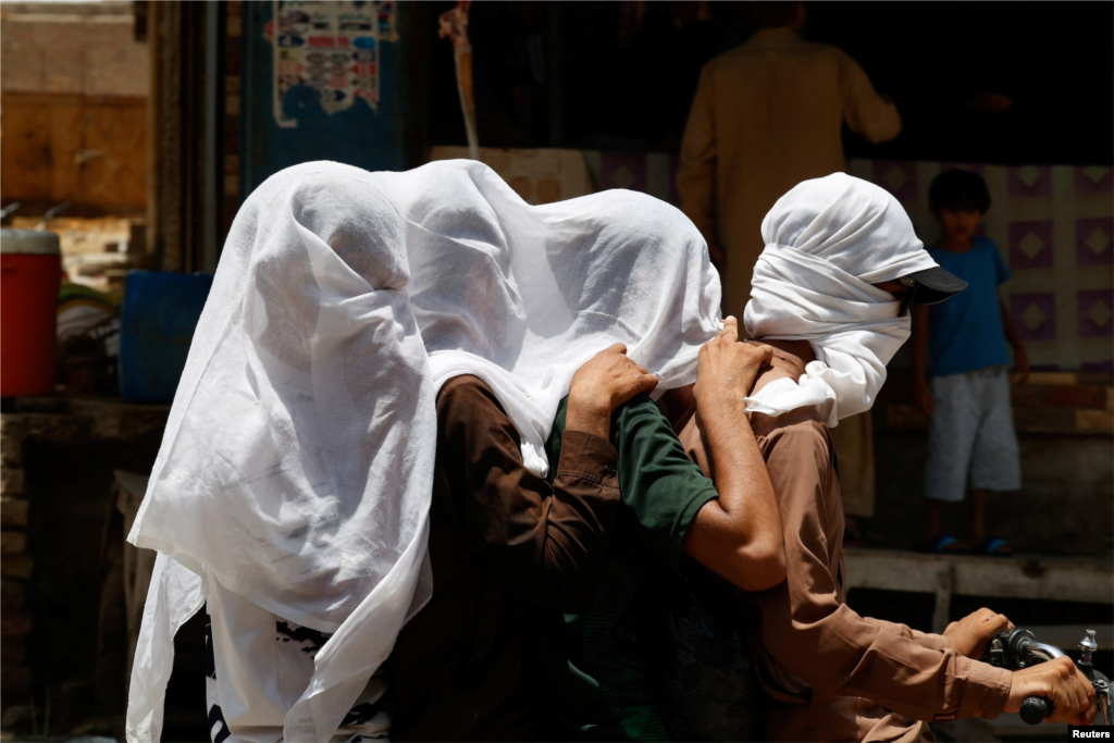 با ادامه موج گرما در پاکستان، برخی موتورسواران سر خود را با پارچه خیس برای خنک شدن و دوری از نور خورشید می پوشانند