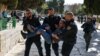 Polisi Israel menahan seorang pria Palestina di Masjid Al-Aqsa menyusul bentrokan yang terjadi lokasi tersebut pada 5 April 2023. (Foto: AFP/Ahmad Gharabli)