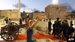 Seorang pria berswafoto saat pejabat kota Tripoli bersiap untuk menembakkan meriam Iftar menandai waktu untuk berbuka puasa di Martyrs Square, di ibu kota Libya, Tripoli, pada hari pertama bulan suci Ramadan, 23 Maret 2023. (Mahmud Turkia/AFP)