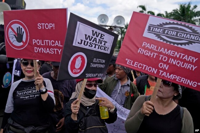 Para pengunjuk rasa membawa poster saat unjuk rasa di luar gedung parlemen di Jakarta, Selasa, 5 Maret 2024. (Foto: AP)