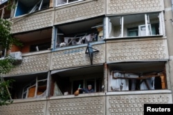 14일 러시아 군의 공습으로 손상된 우크라이나 하르키우 주의 아파트. 깨진 창문 안쪽으로 주민들이 거주하고 있다.