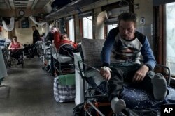 Patients wait for departure inside a specially equipped railway carriage as the Red Cross evacuates sick people from the war-hit Donetsk region in Pokrovsk, Ukraine, Thursday, May 18, 2023.