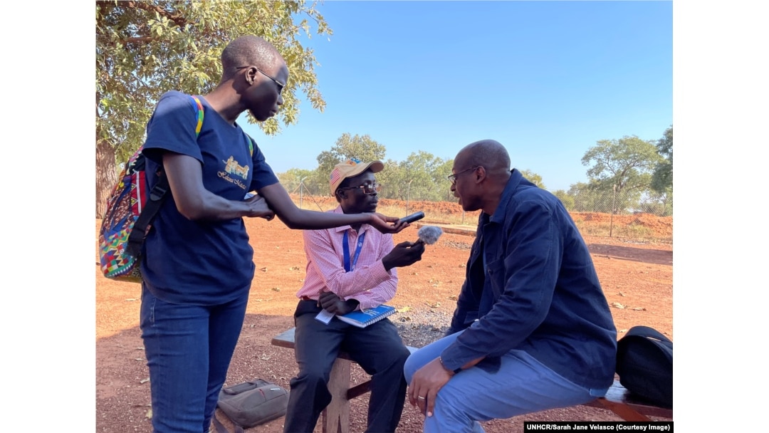 In this undated image provided by UNHCR, Assistant High Commissioner for Operations Raouf Mazou speaks with radio journalist Jabrallah Tia.