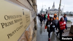 FILE - Picketers march around the Office of the Prime Minister and Privy Council as approximately 155,000 public sector union workers with the Public Service Alliance of Canada (PSAC) continue to strike, in Ottawa, Ontario, Canada April 24, 2023. 