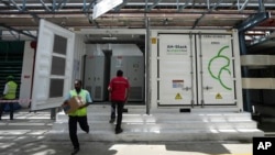 FILE - A worker walks in front of the 500-kilowatt battery energy storage system inside the Hindustan Coca-Cola Beverages factory in Thiruvallur district, on the outskirts of Chennai, India, July 16, 2024. 