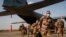 FILE - French soldiers disembark from a US Air Force C130 cargo plane at Niamey, Niger, base, on June 9, 2021. 