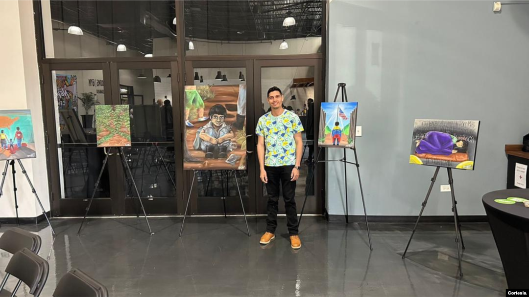 Yeison Pérez posando junto a su exhibición que muestra la ruta
migratoria que recorrió.