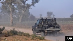 FILE - Members of the Cameroonian Rapid Intervention Force patrol on the outskirt of Mosogo in the far north region of the country where Boko Haram jihadist have been active since 2013, on March 21, 2019. 