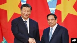 រូបឯកសារ៖ ប្រធានាធិបតីចិនលោក Xi Jinping ចាប់ដៃនាយករដ្ឋមន្ត្រី​វៀតណាមលោក Pham Minh Chinh នៅ​វិមាន​រដ្ឋាភិបាល​ក្នុង​ប្រទេសវៀតណាម កាលពីថ្ងៃទី១៣ ខែធ្នូ ឆ្នាំ២០២៣។