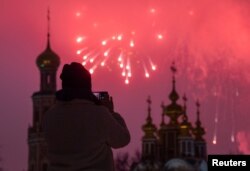 Una persona filma fuegos artificiales que explotan detrás del monasterio Novodevichy en medio de las celebraciones del día del Defensor de la Patria, en Moscú, Rusia, el 23 de febrero de 2024. Foto: Reuters