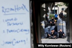 Petugas Brimob beristirahat di dekat kantor polisi yang rusak setelah kerusuhan usai pengumuman hasil pemilihan presiden pada Pilpres 2019 di luar kantor Badan Pengawas Pemilihan Umum (Bawaslu) di Jakarta, 23 Mei 2019. (REUTERS/ Willy Kurniawan)