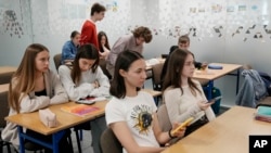 Students use their smartphones at a school run by the Unbreakable Ukraine foundation as they prepare for Ukraine's state final examinations, which are needed to enter university, in Warsaw, Poland, Wednesday June 7, 2023. (AP Photo/Czarek Sokolowski)
