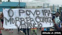 Manifestantes seguram um cartaz demonstrando o seu apoio a Venâncio Mondlane, que concorreu à liderança de Maputo