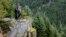 In this undated photo provided by Madeline Hartman, Johnny Jackson and Carol Logan stand on a rock outcropping surrounded by forest on Mount Hood, Ore. 