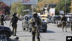 Sejumlah anggota tim keamanan Haiti berjaga di dekat tiga lokasi stasiun di pusat kota Port-au-Prince, pada 9 Maret 2024, di tengah kekerasan geng yang melanda wilayah tersebut. (Foto: AP/Odelyn Joseph)