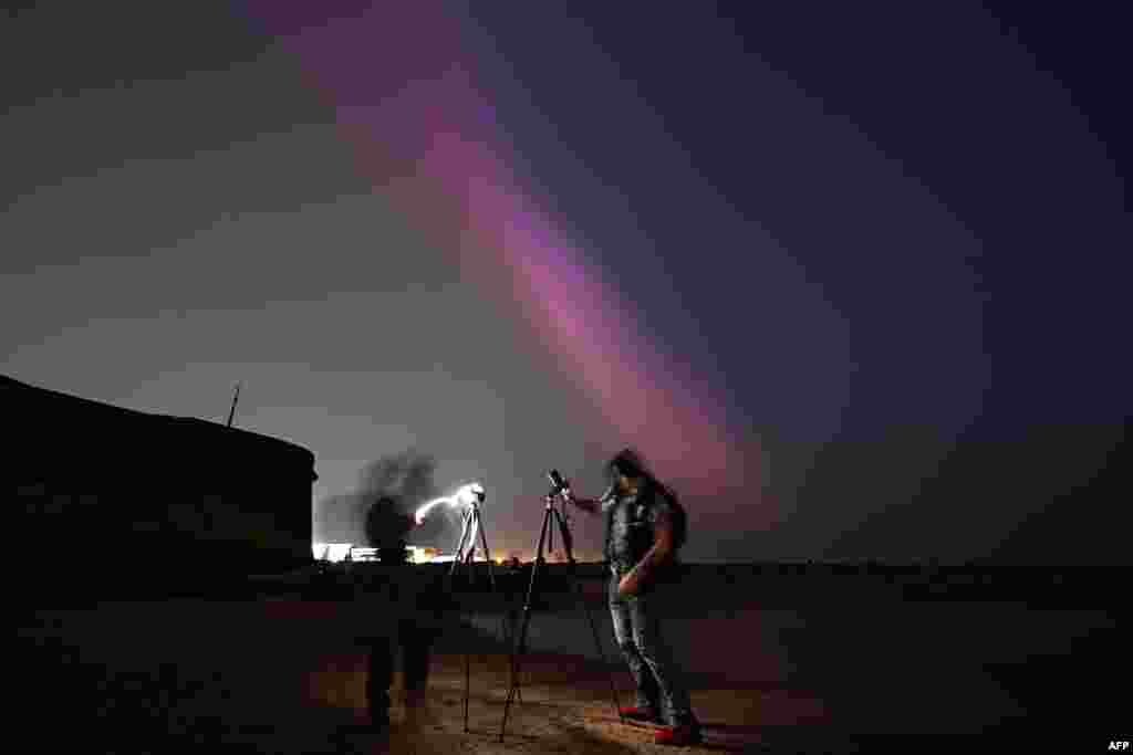 People gather to take photographs of the aurora borealis in New Brighton in northwest England, late May 10, 2024.
