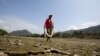 FILE - A fisherman walks on the dry, cracked shore of the Magdalena River, the longest and most important river in Colombia, in the city of Honda, Jan. 14, 2016. El Nino is expected to bring extreme weather across the globe in 2023, from droughts to cyclones.