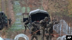 资料照片：波兰军人在与加里宁格勒的边境地区架设铁丝网。（2022年11月2日）