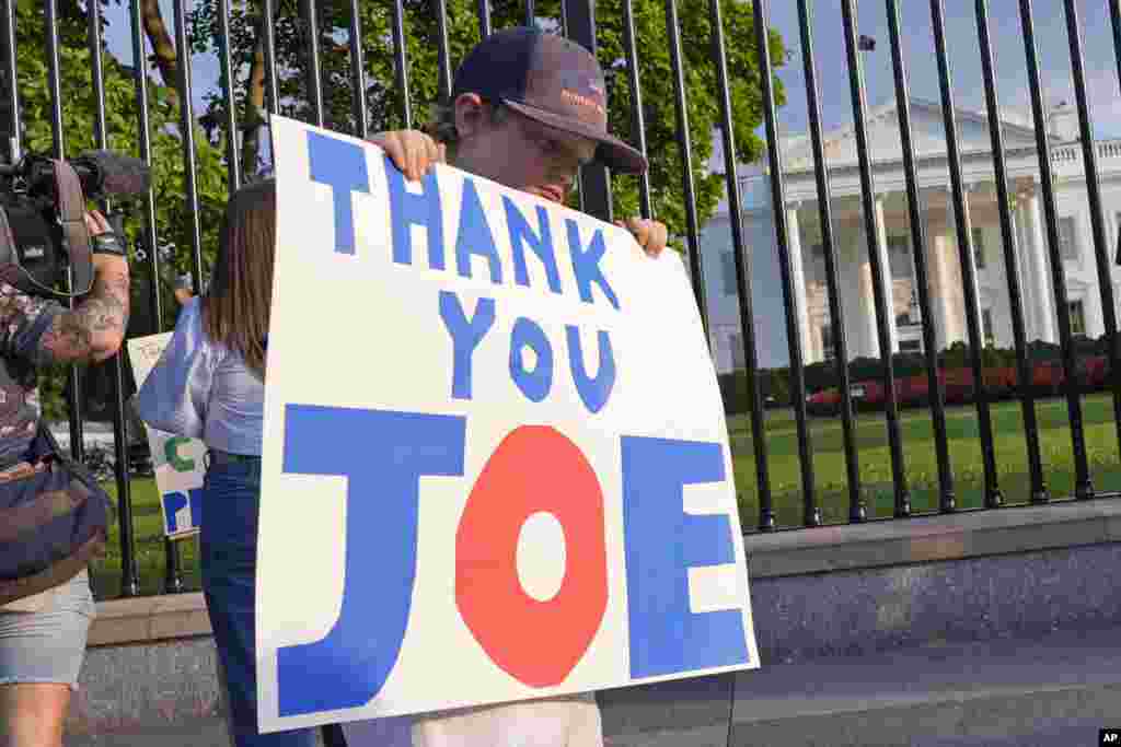 Hugh Kieve, de 10 años,&nbsp; sostiene un cartel frente a la Casa Blanca con la frase &quot;Gracias, Joe&quot; mientras él y su familia salen a mostrar su apoyo al presidente Joe Biden.