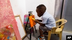 Ace-Liam Nana Sam Ankrah, who will turn 2 in July, paints at his mother's art gallery in Accra, Ghana, May 27, 2024.