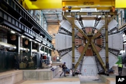 In this Feb. 29, 2008 file photo, the last element, weighing 100 tons, of the ATLAS experiment is lowered into the cave at the CERN research center near Geneva, Switzerland. (AP Photo/Keystone, Martial Trezzini)
