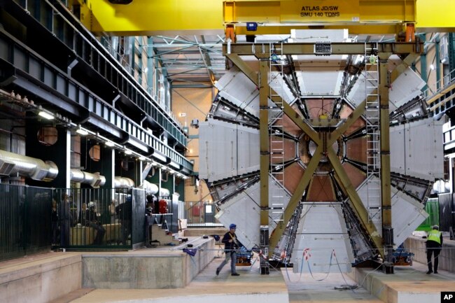 In this Feb. 29, 2008 file photo, the last element, weighing 100 tons, of the ATLAS experiment is lowered into the cave at the CERN research center near Geneva, Switzerland. (AP Photo/Keystone, Martial Trezzini)