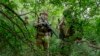 Rusya Savunma Bakanlığı Basın Servisi tarafından 12 Haziran 2024 Çarşamba günü yayınlanan videodan alınan bu fotoğrafta Rus askerleri Ukrayna'da açıklanmayan bir yerde ormanda yürüyor.