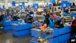 FILE: Cashiers process purchases at a Walmart Supercenter in North Bergen, N.J., on Thursday, Feb. 9, 2023. Inflation fell in May, according to figures released by Washington on June 30, 2023.