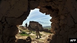 FILE - Pakistani soldiers stand guard in the Bajaur region, on March 2, 2010. 