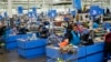 FILE - Cashiers process purchases at a Walmart Supercenter in North Bergen, N.J., on Feb. 9, 2023.