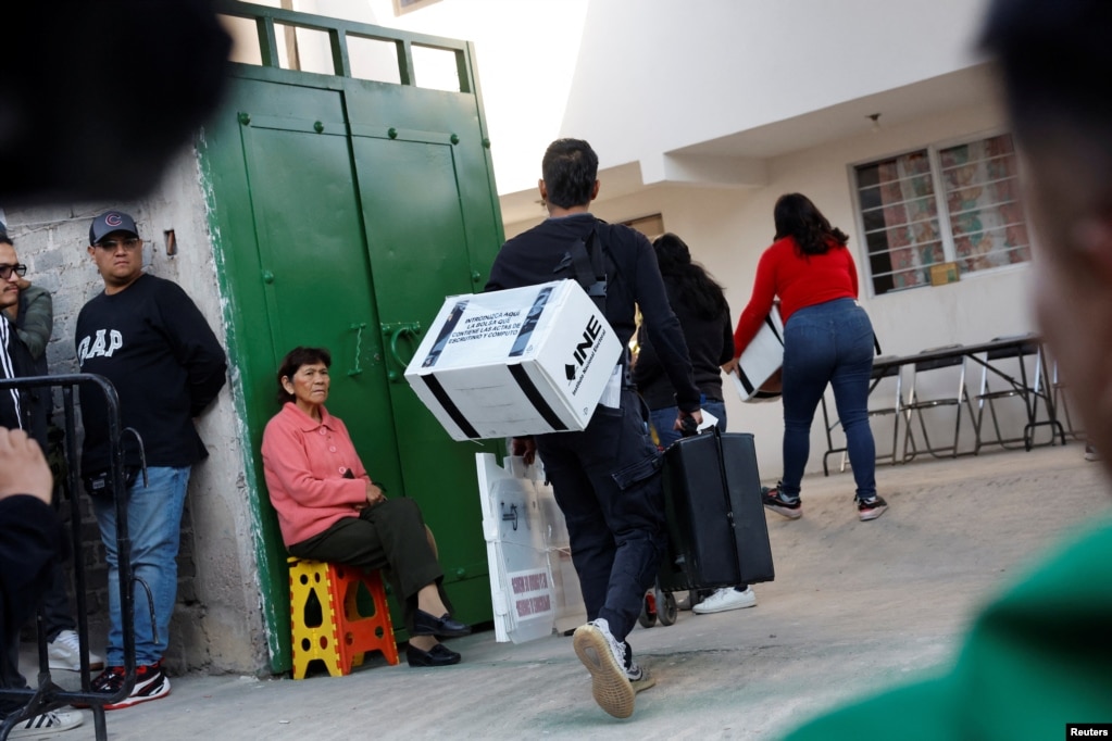 Trabajadores electorales caminan en el centro electoral donde Claudia Sheinbaum, candidata presidencial del partido gobernante MORENA, votará durante las elecciones generales, en la Ciudad de México.