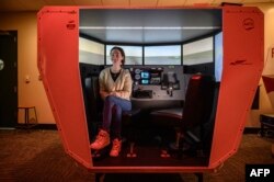 Pelajar pilot Caitlyn Blanco berpose seusai sesi pelatihan di simulator penerbangan Farmingdale State College di Farmingdale, New York, 28 Februari 2023. (Ed JONES / AFP)