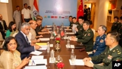Indian Defence Minister Rajnath Singh, seated third left, attends a meeting with his Chinese counterpart Li Shangfu, third right, during the Shanghai Cooperation Organization Defence Minister's Meeting in New Delhi, April 27, 2023. 