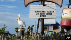 Visitors pass a restaurant closed in advance of Beryl in Port Aransas, Texas, July 6, 2024.