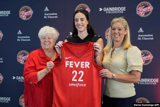 FILE - Indiana Fever's Caitlin Clark, middle, with general manager Lin Dunn, left, and head coach Christie Sides after a WNBA news conference, April 17, 2024, in Indianapolis. (AP Photo/Darron Cummings)