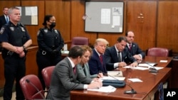 O antigo presidente Donald Trump na sala do tribunal de Nova Yorque, rodeado de advogados, quando foi formalmente inidiciado em Abril de 2023