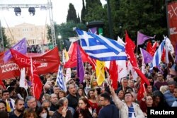 Supporters of leftist Syriza party wave flags during the speech of leftist Syriza party leader Alexis Tsipras in a pre-election rally in Athens, Greece, May 18, 2023.