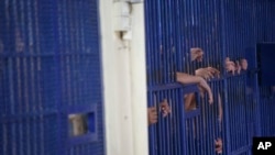 FILE - Detainees stand behind cell bars at the police Immigration Detention Center in Bangkok on Jan. 21, 2019. Foreign asylum seekers in Thailand worry that they will end up in detention centers if they apply for a new protection program that is to begin on Sept. 22, 2023.