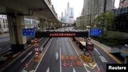 FILE - A worker in a protective suit walks at an entrance to a tunnel leading to the Pudong area across the Huangpu river, after restrictions on highway traffic amid the lockdown in Shanghai, China March 28, 2022.