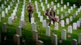 Members of the 3rd U.S. Infantry Regiment also known as The Old Guard place flags in front of each headstone at Arlington National Cemetery in Arlington, Thursday, May 25, 2023, to honor the Nation's fallen military heroes ahead of Memorial Day. (AP Photo/Andrew Harnik)