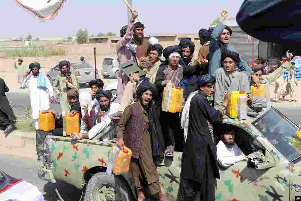 Taliban fighters carry yellow canisters intended to represent homemade explosives as they celebrate the third anniversary of the withdrawal of U.S.-led troops from Afghanistan, in Lashkar Gah, Helmand province, Afghanistan, Aug. 14, 2024.