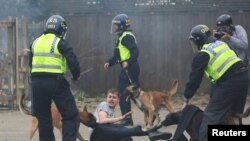 Police dogs attack a man during an anti-immigration protest in Rotherham, Britain, Aug. 4, 2024. 