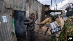 Lapolis bat yon manifestan ki te kache nan yon kay apre yo lanse gaz lakrimojen pou fose li soti nan Kibera, yon katye defavorize kapital la, Nairobi, 20 Mas, 2023. 