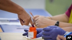 A Malaysian voter gets a finger marked with ink before casting his vote at a polling station in Selayang, outskirt of Kuala Lumpur, Malaysia, Aug. 12, 2023.