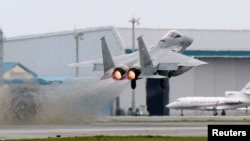 Pesawat tempur F-15 Pasukan Bela Diri Udara Jepang mengacak-acak di pangkalan Pasukan Bela Diri Udara Naha di Naha, prefektur Okinawa, Jepang, dalam foto ini diambil oleh Kyodo 13 April 2015. (Kyodo/via Reuters)