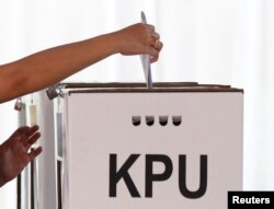 Pemilih memasukkan surat suara usai mencoblos di Jakarta, 17 April 2019. (Foto: REUTERS/Edgar Su)