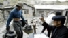 FILE - A Chinese villager weighs antimony he collected from a mine at Lengshuijiang in China's southern province of Hunan, Aug. 10, 2003. China is the largest producer of antimony and is starting export controls of the mineral beginning Sept. 15, 2024.