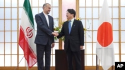 Japanese Foreign Minister Yoshimasa Hayashi, right, and Iranian counterpart Hossein Amir-Abdollahian shake hands before their meeting, Aug. 7, 2023, in Tokyo. 
