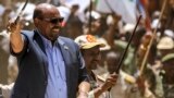 FILE: Then-Sudan President Omar al-Bashir (L) tours in a vehicle with Rapid Support Forces (RSF) paramilitaries chief Mohamed Hamdan Daglo, at the RSF headquarters in South Darfur State. Reuters reports that al-Bashir people are now backing Sudan army chief Abdel al-Burhan. 