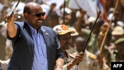 FILE: Then-Sudan President Omar al-Bashir (L) tours in a vehicle with Rapid Support Forces (RSF) paramilitaries chief Mohamed Hamdan Daglo, at the RSF headquarters in South Darfur State. Reuters reports that al-Bashir people are now backing Sudan army chief Abdel al-Burhan. 